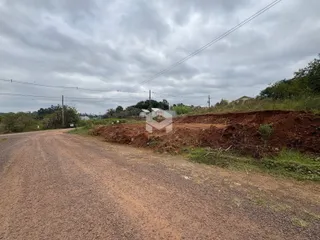 Uma estrada de terra leva a uma área de terra revolvida ao lado de uma propriedade.