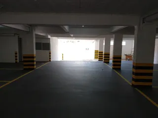 Vista de um espaço aberto com colunas em um estacionamento.