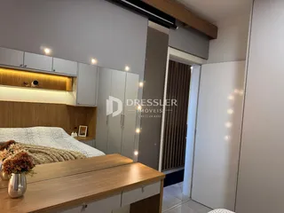 Quarto com armários embutidos e cabeceira de madeira em um imóvel no Brasil.