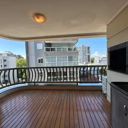Varanda de madeira com vista para a paisagem urbana.