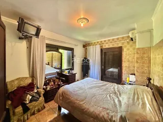 Quarto com cama e móveis de madeira em uma residência.