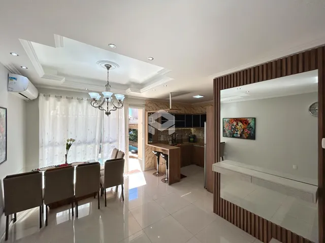 Sala de jantar iluminada com janelas grandes e decoração elegante.