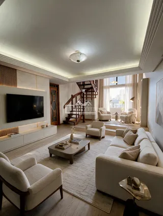 Sala de estar moderna com sofá e decoração clara.