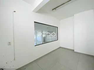 Interior de um ambiente com paredes brancas e piso claro.
