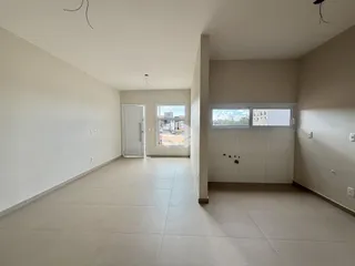 Hall de entrada com piso de cerâmica e paredes brancas.