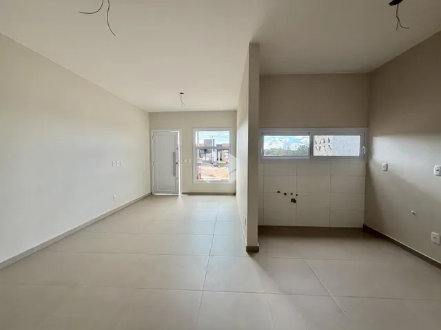Hall de entrada com piso de cerâmica e paredes brancas.