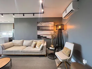 Sala de estar moderna com sofá e poltrona em um ambiente claro.