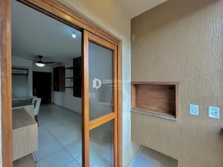 Vista de uma sala de estar com piso de cerâmica e portas de madeira em uma residência.