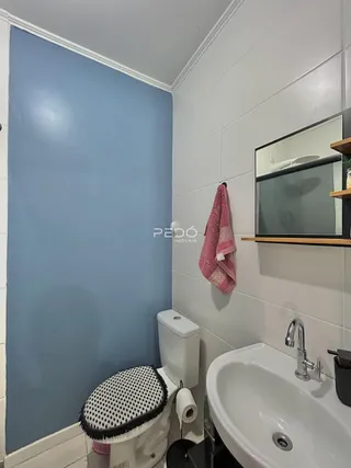 Banheiro com paredes azuis e revestimento branco.