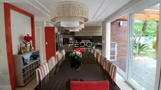 Vista de uma sala de jantar com mesa longa e cadeiras.