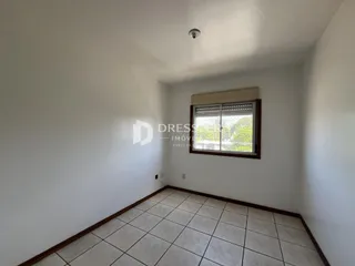 Foto de um corredor interno com piso de cerâmica clara.