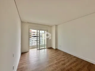 Interior de um cômodo com piso de madeira e porta de vidro.