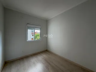 Ambiente interno de uma sala com piso de madeira clara.