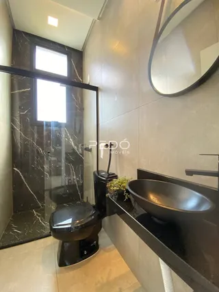 Foto de um banheiro moderno com revestimento de mármore escuro.