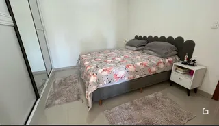 Quarto com cama e tapete no interior da propriedade.