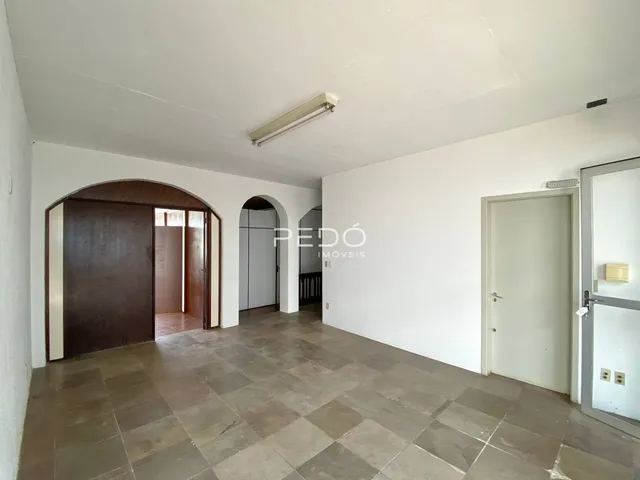 Interior de um corredor com piso de cerâmica e paredes brancas.