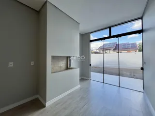 Interior de uma sala com piso de madeira clara e porta de vidro grande.