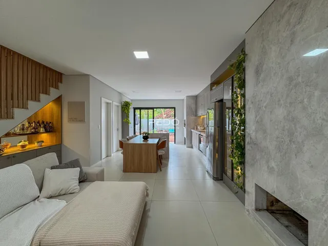 Sala de estar com piso claro e detalhes em madeira.