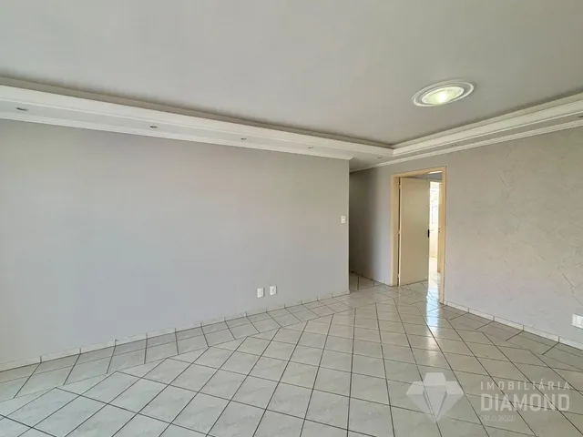 Vista interna de uma sala com piso de cerâmica e paredes brancas.
