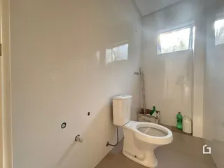 Foto de um banheiro interno com azulejos brancos e vaso sanitário branco.