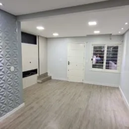 Sala de estar com piso claro e paredes brancas em um imóvel.