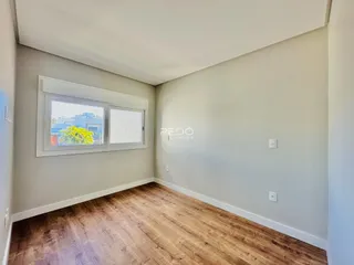 Sala de estar com piso de madeira clara e paredes cinzas.