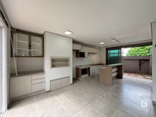 Ambiente aberto da cozinha e sala de estar com piso de cerâmica.