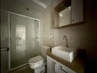 Foto de um banheiro interno com box de vidro e vaso sanitário.