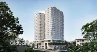 Fachada de um edifício residencial em Lajeado, Brasil, cercado por vegetação.