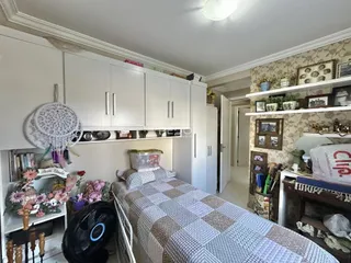 Quarto com cama e armários brancos na residência.