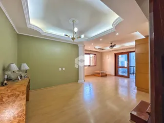 Esta é uma foto de uma sala de estar ampla com paredes verdes e piso claro.