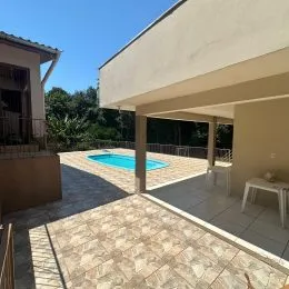 Foto de uma área externa com piscina e piso de cerâmica.