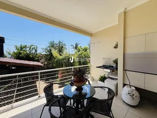 Vista da varanda com mobiliário de exterior e vegetação.
