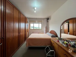 Quarto com armários de madeira e cama no interior de uma residência.