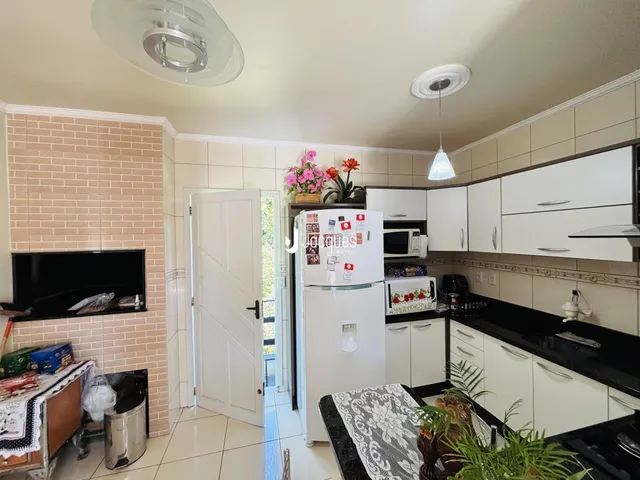 Interior da cozinha e sala de jantar de uma residência.
