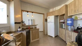 Cozinha com armários de madeira e piso de cerâmica.