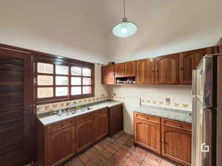 Foto de uma cozinha com armários de madeira e piso de tijolo na Lajeado.