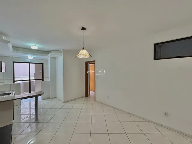 Hall de entrada com piso de cerâmica e paredes brancas.