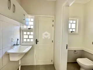 Foto de um banheiro com azulejos brancos e bancada clara.