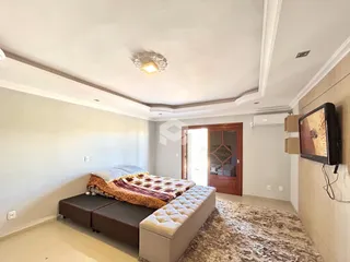 Quarto com cama, sofá e tapete no interior da residência.