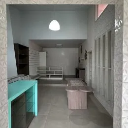 Hall de entrada com paredes cinzas e piso claro.
