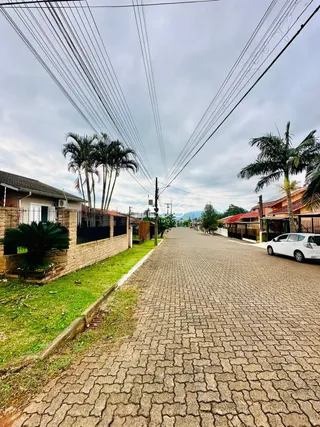 Vista de uma rua pavimentada em Lajeado, Brasil, com vegetação lateral.