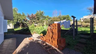Vista externa da propriedade com jardim e muro de tijolos.