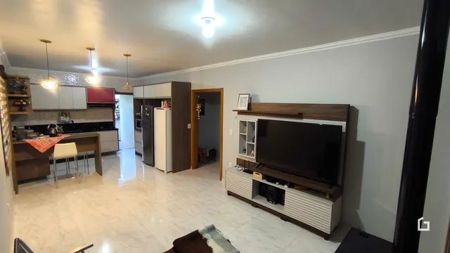 Sala de estar com cozinha integrada e piso de cerâmica.
