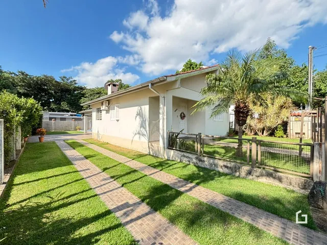 Vista da fachada de uma casa com jardim e calçada no Brasil