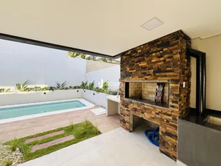 Foto da área da piscina e jardim com parede de pedra na propriedade.