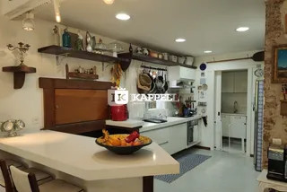 Foto de uma cozinha com bancadas brancas e área de refeições em um imóvel.