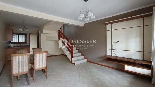 Sala de estar com escadaria e móveis de madeira.