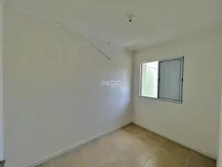 Ambiente interno de uma sala com paredes brancas e piso de cerâmica.
