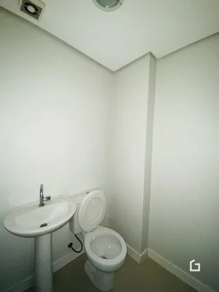 Foto de um banheiro interno com pia e vaso sanitário.